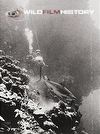 Hans Hass filming a shark swimming along a reef