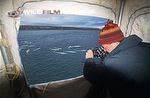 Doug Allan filming beluga whales from a scaffold tower for Blue Planet