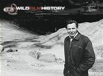 David Attenborough outside a cave entrance during filming for Life on Earth