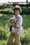 Presenter and cameraman Simon King as a boy holding a red fox